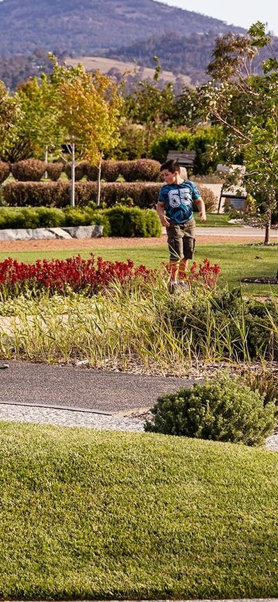 landscape image of the green gardens with two kids running
