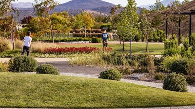 landscape image of the green gardens with two kids running