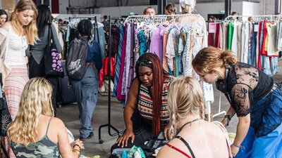people rummaging through clothing sale bins
