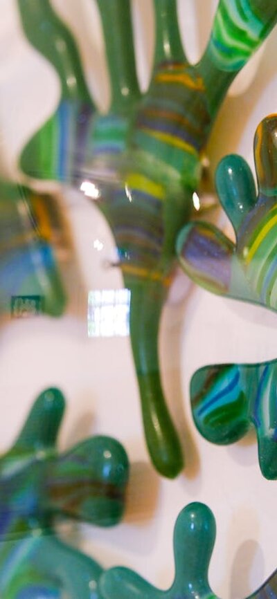 Close up of a glass sculpture of seaweed made from greens inside a transparent glass bubble