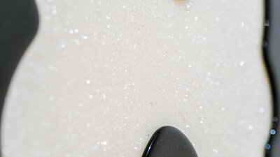 Close up of a glass panel with a white glittery curved shape surrounded by black