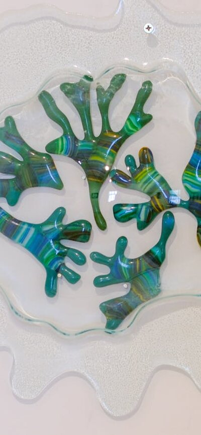 a glass sculpture of seaweed made from greens inside a transparent glass bubble