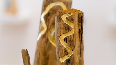 Sculpture made from found wooden logs and gold leaf