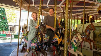 A man and a young girl riding Canberra's historic merry-go-round A man and a young girl riding Canberra's historic merry-go-round
