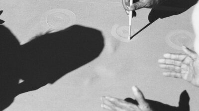 Dreamings - The Art of Aboriginal Australia (1988) Close up of women's shadows and hands painting the ancestral design of the Sugar leaf dreaming