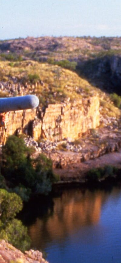 Sounds Like Australia (1987) A film crew member recording sound with a gorge and rocky landscape in the background.
