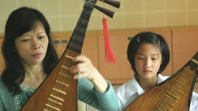 Vu Thi Mai Phuong and a student with traditional Vietnamese Bau instruments