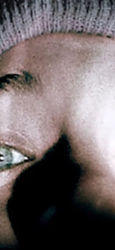 The Blair Witch Project (1999) Close up of selfie image of a person wearing a beanie in the dark