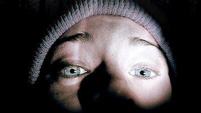 Close up of selfie image of a person wearing a beanie in the dark