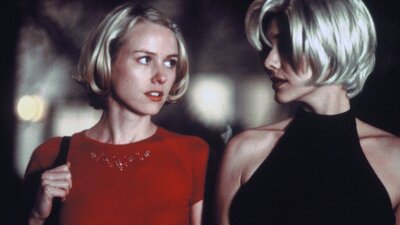 Two women with short blonde hair talking and walking