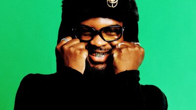 Genesis Owusu with hands on his cheeks smiling