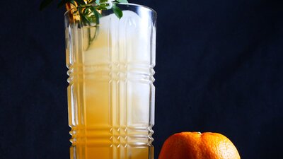 A Mandarin Gin 'Sonic' Cocktail Cocktail in a tall glass with a mandarin.