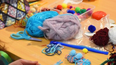 Kids making art with pom poms and pipe cleaners