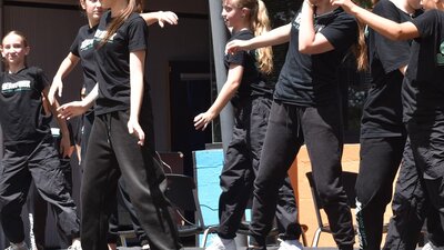 Teenage girls wearing black doing hip hop dances