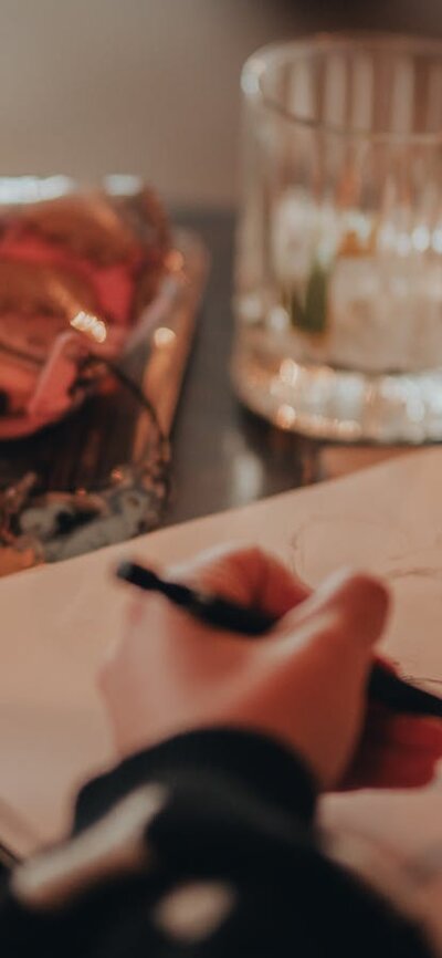 Person sketching with pastels and pencil case next to them