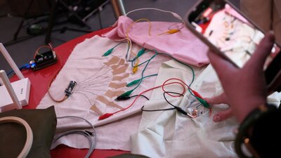 Amplified Textiles Workshop 2025 A photo of some textile fabric swatches with electrical nodes and cords attached