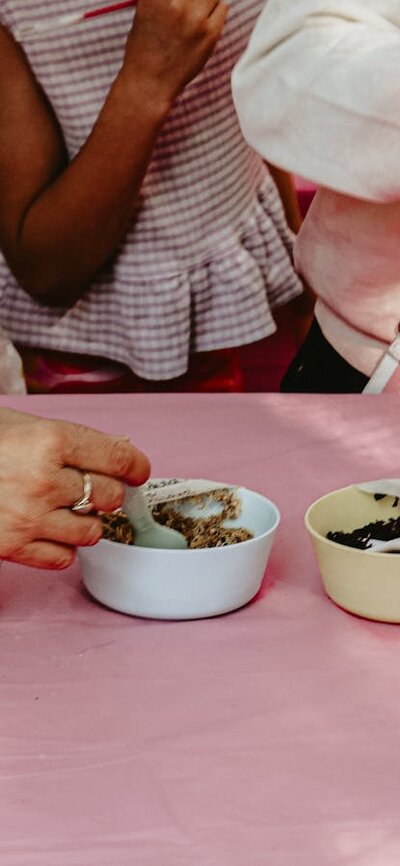 An image of potion ingredients on a table, with kids hands taking the ingredients.