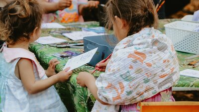Children sitting around a table doing colouring in activities