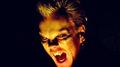 Close up of vampire baring teeth with glowing eyes