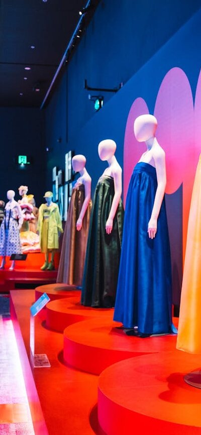 Korean fashion being displayed on mannequins with a young man walking alongside the display.