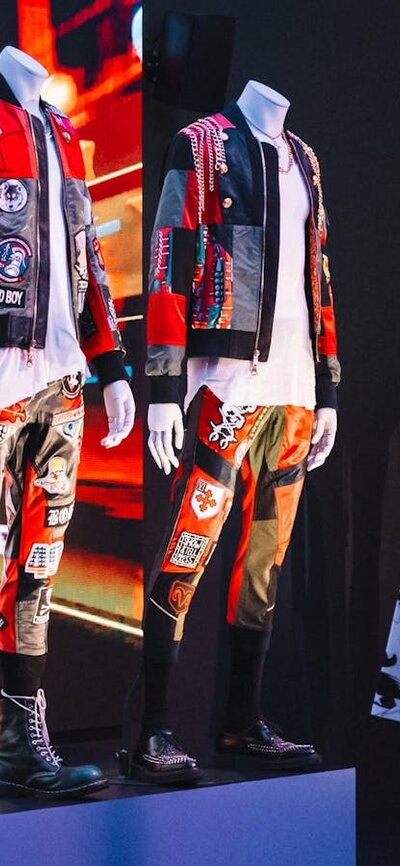 Korean fashion being displayed on mannequins in an exhibition and three young girls  looking at them