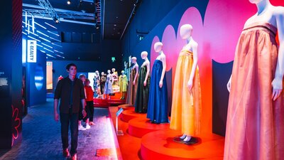 Korean fashion being displayed on mannequins with a young man walking alongside the display.