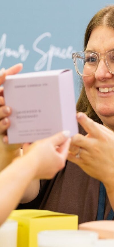 Green Candle Co handing a candle to a customer