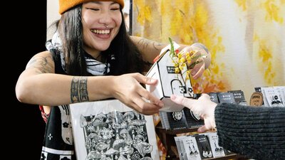 Myii Creative handing a customer their purchase
