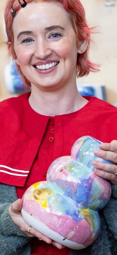 Rhiannon Gill Ceramics holding a colourful ceramic vase