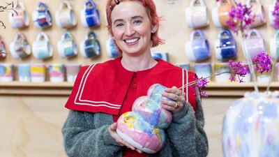 Rhiannon Gill Ceramics holding a colourful ceramic vase