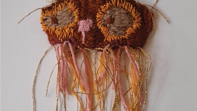 A textile wall hanging owl in shades of brown