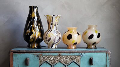 Four glass vessels on a shelf