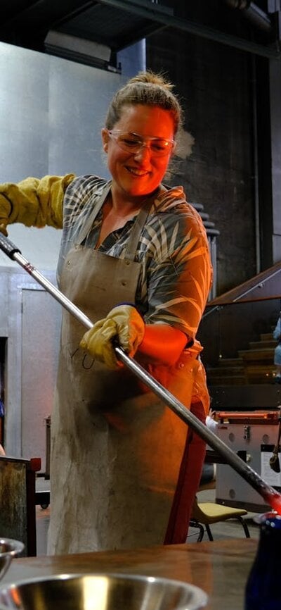 Participant in the Glassworks hotshop working with molten glass