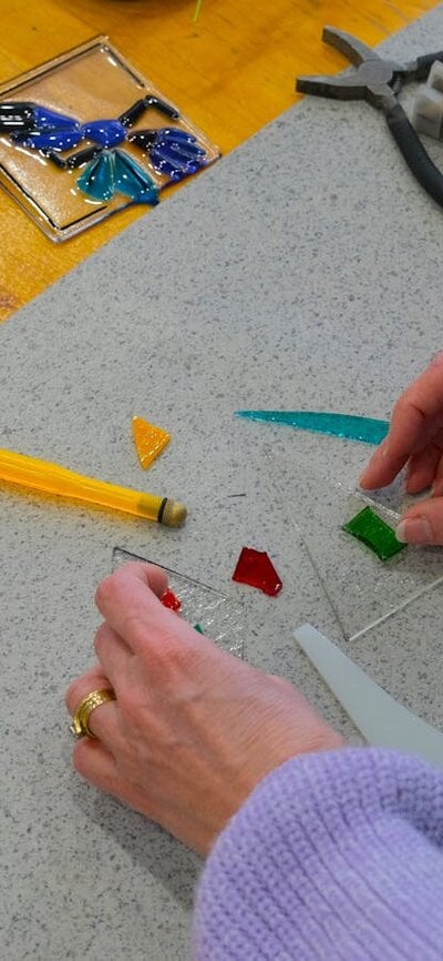 Participant arranging glass tiles to make a Christmas ornament