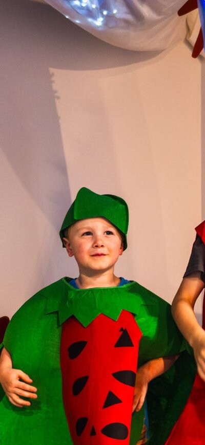 Three children dressed as fruits and vegetables at Hop In