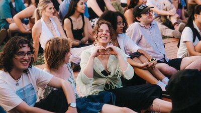 Image of people smiling and happy sitting on grass