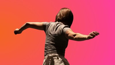 A woman faces away from the camera with her arms out. The background is an orange and pink gradient.