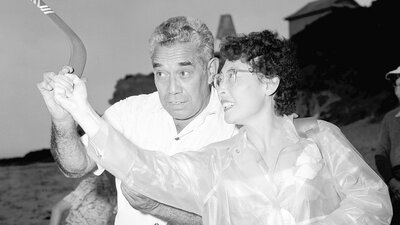 A man teaches women how to throw a boomerang in 1957.