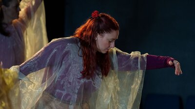 Emma Batchelor dances. Her eyes are closed, she seems concentrated, but light in her movement.