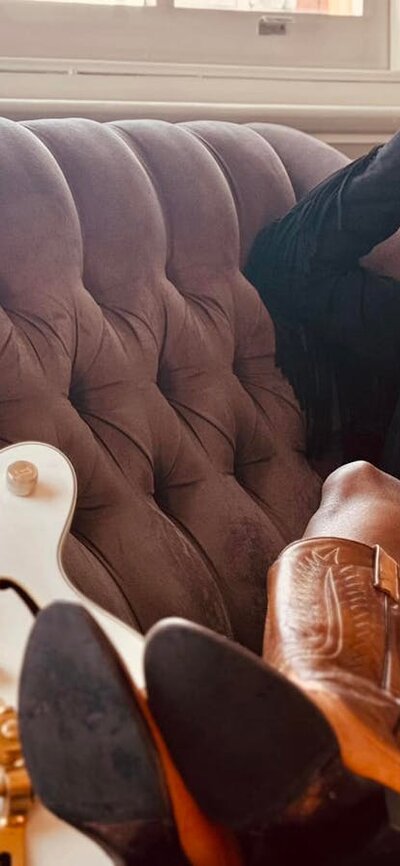 Roshani Roshani sitting on lounge with guitar