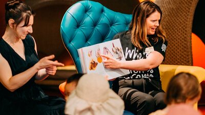 Photo of a Museum staff member and an Auslan interpreter signing a book in the Discovery Centre