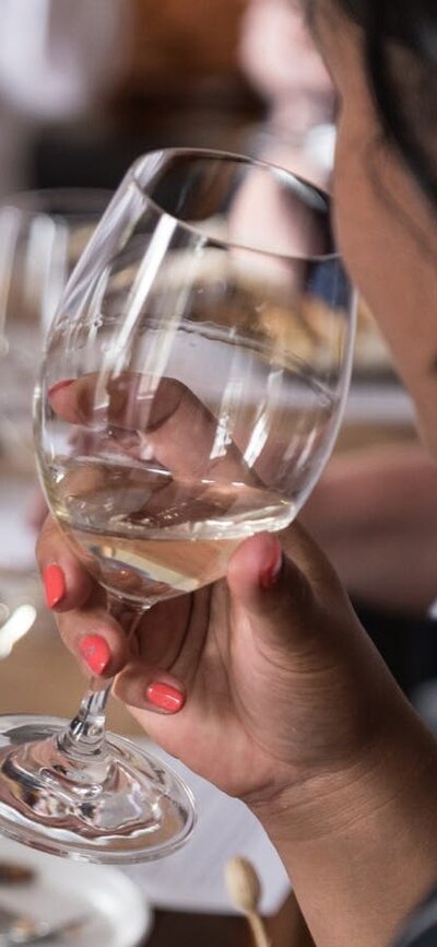 A young woman raises a glass to her lips