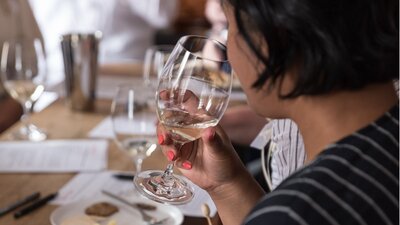 A young woman raises a glass to her lips