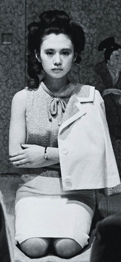 Black and white image of woman kneeling on floor with arms crossed