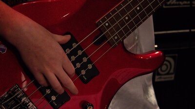 close up of someone playing bass guitar
