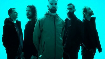 The five members of Karnivool in a neone blue background looking different ways off camera.