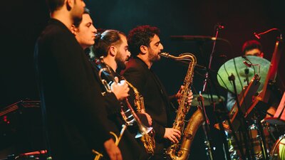 4 musicians playing brass instruments, shot in profile