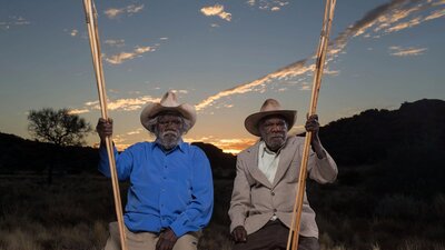 Alec Baker, Yankunytjatjara people, and Kunmanara (Peter) Mungkuri, Yankunytjatjara people, 2017 Two first nations elders in sitting in country near Amaroona at sunset with hand carved spears
