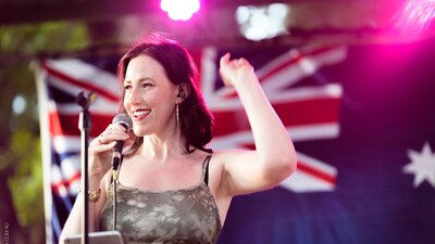 Female vocalist with Australian flag in background