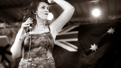 Female vocalist with Australian flag in background